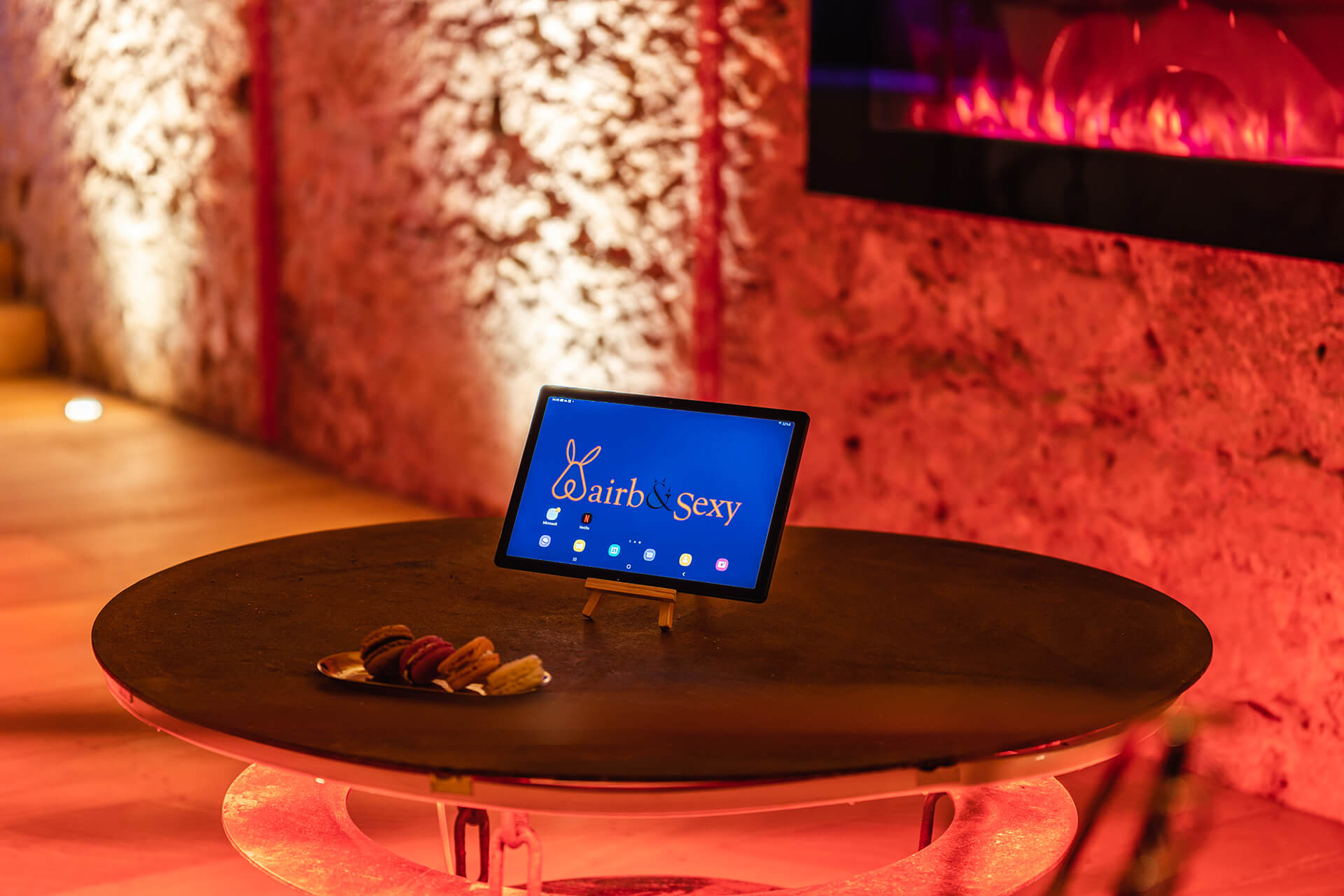 Tablette avec logo Airb&Sexy devant une cheminée